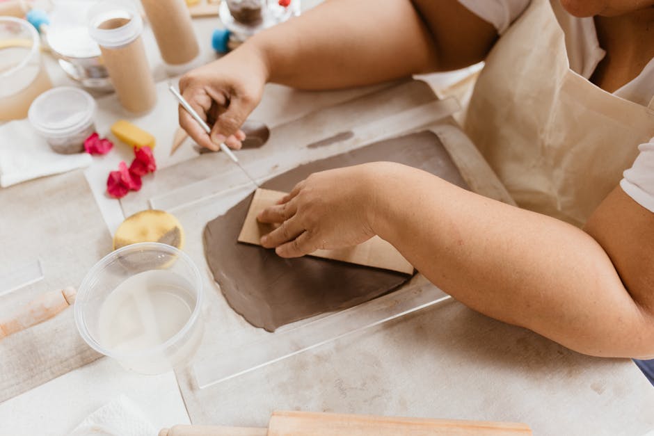 Close-up of a woman crafting with clay indoors, capturing creative artistry.